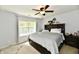 Bedroom features a ceiling fan, natural light, bedside tables, and an upholstered headboard at 5611 Burning Tree Ct, Indianapolis, IN 46239