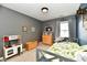 A charming bedroom with neutral walls, a play kitchen, and natural light from the window at 5611 Burning Tree Ct, Indianapolis, IN 46239