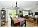 Dining room features hardwood floors, modern lighting, access to the backyard, and shares an open space with the living room at 5611 Burning Tree Ct, Indianapolis, IN 46239