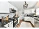 Well-equipped kitchen with stainless steel appliances, white cabinets, and a stylish hanging pot rack at 5611 Burning Tree Ct, Indianapolis, IN 46239