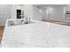 Close-up of the kitchen island featuring a stainless steel sink, modern faucet, and luxurious marble countertops at 564 Plowman Dr, Shelbyville, IN 46176