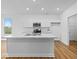Modern kitchen featuring white cabinets, stainless steel appliances, marble countertops, and an eat-in island at 564 Plowman Dr, Shelbyville, IN 46176