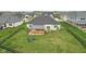 Aerial view of the backyard showcasing the covered patio, fire pit area, and large lawn, perfect for outdoor living at 5667 Skylark Dr, Greenwood, IN 46143