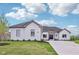 Stunning, white brick home with a well-manicured lawn and a concrete driveway at 5667 Skylark Dr, Greenwood, IN 46143