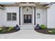 Covered front entrance featuring double doors, landscaping, and a concrete walkway at 5667 Skylark Dr, Greenwood, IN 46143