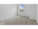 A bright bedroom with neutral carpet, natural light from the window, and white walls at 576 Plowman Dr, Shelbyville, IN 46176