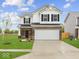 Charming two-story home with a well-maintained lawn and attached two-car garage at 576 Plowman Dr, Shelbyville, IN 46176