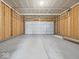 A spacious, unfinished garage with a white garage door and ample room for parking and storage at 576 Plowman Dr, Shelbyville, IN 46176