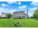 Large grassy backyard with a firepit, swing set, and privacy fence, perfect for entertaining at 6624 Lakestone Ct, Indianapolis, IN 46237