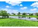 Serene backyard overlooking a pond with mature trees, well-manicured lawn, and neighborhood views at 6624 Lakestone Ct, Indianapolis, IN 46237