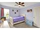 A well-lit bedroom with a ceiling fan and bed with purple bedding at 6624 Lakestone Ct, Indianapolis, IN 46237