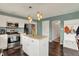 Kitchen showcases stainless steel appliances, white cabinets and island, and trendy pendant lighting at 6624 Lakestone Ct, Indianapolis, IN 46237