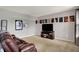 Spacious living room with a large television, entertainment center, and comfortable leather seating at 6624 Lakestone Ct, Indianapolis, IN 46237