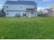 Large backyard with a pergola-covered patio area featuring a stone fire pit and seating, ideal for outdoor gatherings at 6625 Wolverine Way, Indianapolis, IN 46237