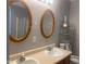 Bathroom boasts dual sinks with framed mirrors, complemented by a functional toilet and storage at 6625 Wolverine Way, Indianapolis, IN 46237