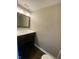 A bathroom with a sink, mirror, lighting, and a brown vanity cabinet at 6625 Wolverine Way, Indianapolis, IN 46237