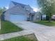 Two-story home with brick facade, large driveway, and well-maintained lawn at 6625 Wolverine Way, Indianapolis, IN 46237