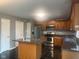 A full view of a kitchen complete with island, stainless steel appliances, and a tile floor at 6625 Wolverine Way, Indianapolis, IN 46237