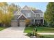 Charming two-story home featuring a stone facade, manicured lawn, and a welcoming front porch perfect for relaxing at 665 Featherstone Dr, Westfield, IN 46074