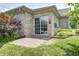 View of a brick-paved back patio with grass and garden bed, sliding door, and partial view of the home's exterior at 6816 Park Square Dr # C, Avon, IN 46123
