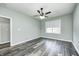 Empty bedroom featuring wood-look floors, neutral walls, a ceiling fan, and a window for natural light at 6816 Park Square Dr # C, Avon, IN 46123