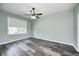 A spacious room offering wood-look floors, a ceiling fan, neutral walls and a sunlit window at 6816 Park Square Dr # C, Avon, IN 46123