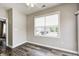 Well-lit bedroom showcasing wood-look floors, a ceiling fan, white trim, and a window overlooking the front yard at 6816 Park Square Dr # C, Avon, IN 46123