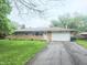 Charming brick ranch home with a long driveway and an attached two car garage at 7109 Chandler Dr, Indianapolis, IN 46217