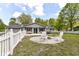 Expansive backyard featuring a fire pit area, patio with bench seating, and a white picket fence at 7118 Mikesell Dr, Indianapolis, IN 46260