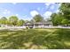 Lush backyard with a well-maintained lawn, mature trees, and a white picket fence at 7118 Mikesell Dr, Indianapolis, IN 46260