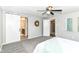 Spacious bedroom with a ceiling fan, gray carpet and a walk through to the bathroom at 7118 Mikesell Dr, Indianapolis, IN 46260