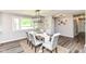 Dining area with wood-look flooring, view of a tree through a window, and decor at 7118 Mikesell Dr, Indianapolis, IN 46260