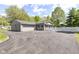 Charming home exterior with gray siding, an attached garage, and a spacious driveway at 7118 Mikesell Dr, Indianapolis, IN 46260