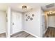 Bright foyer with wood-look floors, decorative mirrors, and a front door with glass panes at 7118 Mikesell Dr, Indianapolis, IN 46260