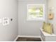 A well-lit laundry room with a window, fresh paint and modern design at 7118 Mikesell Dr, Indianapolis, IN 46260
