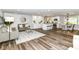 Modern living room with hardwood floors, neutral decor, and seamless flow to kitchen and dining areas at 7118 Mikesell Dr, Indianapolis, IN 46260