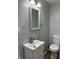 Bathroom featuring a modern sink, decorative mirror, and light grey walls providing a clean aesthetic at 7131 E 14Th St, Indianapolis, IN 46219