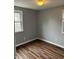 Bedroom featuring two windows, light grey walls, and durable wood-look flooring at 7131 E 14Th St, Indianapolis, IN 46219