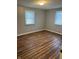 Empty bedroom with light gray walls, two windows with natural light, and wood-look flooring at 7131 E 14Th St, Indianapolis, IN 46219
