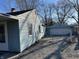 Exterior side view of the home with matching detached garage, showing the home's layout and features at 7131 E 14Th St, Indianapolis, IN 46219