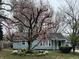 Charming home featuring a large magnolia tree in full bloom and a well-maintained lawn at 7131 E 14Th St, Indianapolis, IN 46219