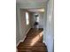 Hallway with wood floors leads to a bright entryway and view through to front door at 7131 E 14Th St, Indianapolis, IN 46219