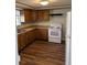 Kitchen showcasing wood cabinets, modern appliances, and durable wood-look flooring at 7131 E 14Th St, Indianapolis, IN 46219