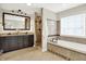 Bathroom boasts dual sinks, standalone tub, and glass shower with tile surround and dark fixtures at 7614 Bishops, Zionsville, IN 46077