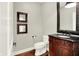 Elegant powder room featuring a dark wood vanity, granite countertop, and decorative mirrors, adding a touch of sophistication at 7614 Bishops, Zionsville, IN 46077