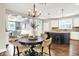 Dining area with dark wood floors, open concept kitchen, white cabinets and dark center island at 7614 Bishops, Zionsville, IN 46077
