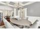 An oval table sits in this dining room with white pillars, modern chandelier and dark hardwood flooring at 7614 Bishops, Zionsville, IN 46077