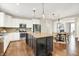 Open concept kitchen with white cabinets, center island, pendant lighting and hardwood floors at 7614 Bishops, Zionsville, IN 46077