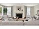 Cozy living room with a stone-surround fireplace, hardwood floors, and large windows at 7614 Bishops, Zionsville, IN 46077