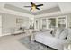Bright main bedroom with a tray ceiling, ceiling fan, sitting area and lots of natural light at 7614 Bishops, Zionsville, IN 46077
